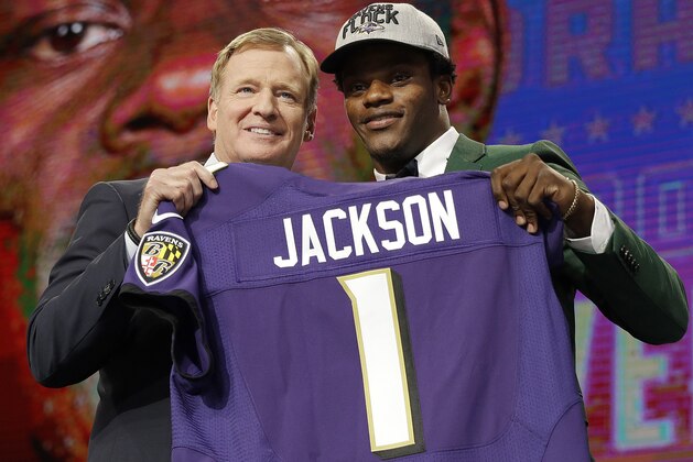 Commissioner Roger Goodell, left, presents Louisville's Lamar Jackson with his Baltimore Ravens jersey during the first round of the NFL football draft, Thursday, April 26, 2018, in Arlington, Texas. (AP Photo/David J. Phillip)