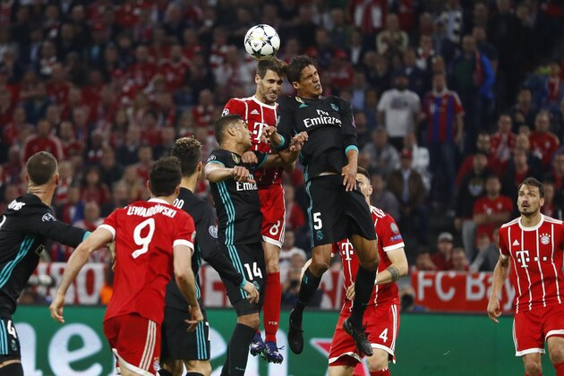 Bayern's Javi Martinez, left, and Real Madrid's Raphael Varane go for a header during the semifinal first leg soccer match between FC Bayern Munich and Real Madrid at the Allianz Arena stadium in Munich, Germany, Wednesday, April 25, 2018. (AP Photo/Matthias Schrader)