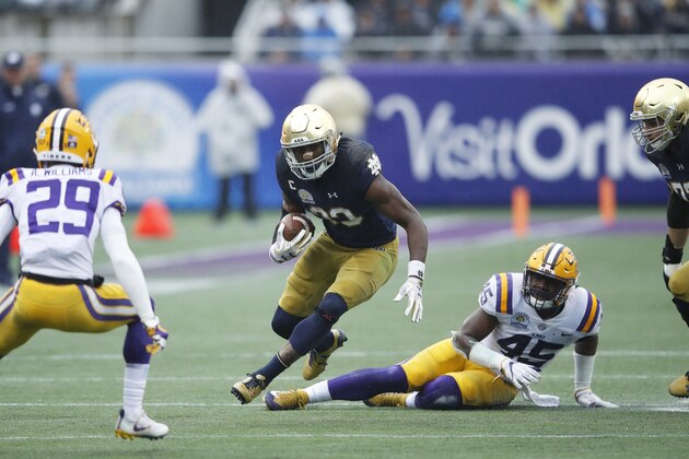 3ORLANDO, FL - JANUARY 01: Josh Adams #33 of the Notre Dame Fighting Irish breaks a tackle while running the ball against Michael Divinity Jr. #45 of the LSU Tigers during the Citrus Bowl on January 1, 2018 in Orlando, Florida. Notre Dame won 21-17. (Photo by Joe Robbins/Getty Images)