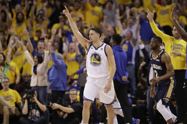 Golden State Warriors' Klay Thompson, center, celebrates after making a 3-point basket next to New Orleans Pelicans' Ian Clark, right, during the first half in Game 1 of an NBA basketball second-round playoff series Saturday, April 28, 2018, in Oakland, Calif. (AP Photo/Marcio Jose Sanchez)