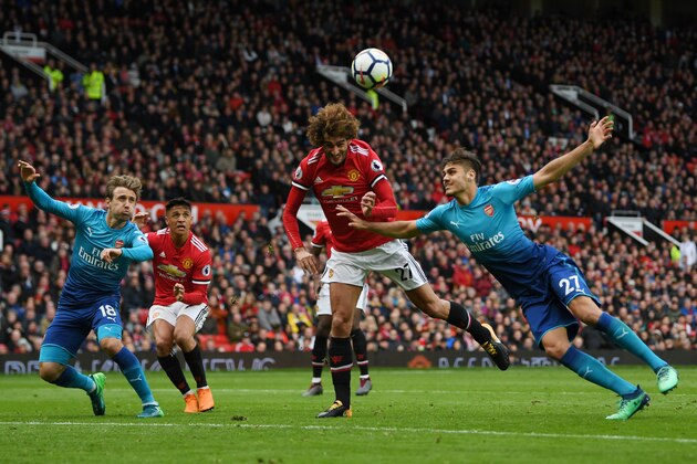 MANCHESTER, ENGLAND - APRIL 29:  Fellaini of Manchester United wins a header over Konstantinos Mavropanos of Arsenal during the Premier League match between Manchester United and Arsenal at Old Trafford on April 29, 2018 in Manchester, England.  (Photo by Shaun Botterill/Getty Images)