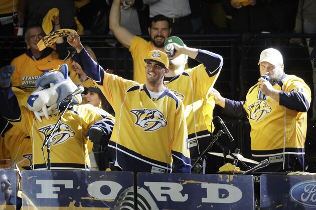Tennessee Titans quarterback Marcus Waves a rally towel as members of the Titans' offensive line drink a beer behind him before Game 3 of the Western Conference final in the NHL hockey Stanley Cup playoffs between the Nashville Predators and the Anaheim Ducks Tuesday, May 16, 2017, in Nashville, Tenn. (AP Photo/Mark Humphrey)