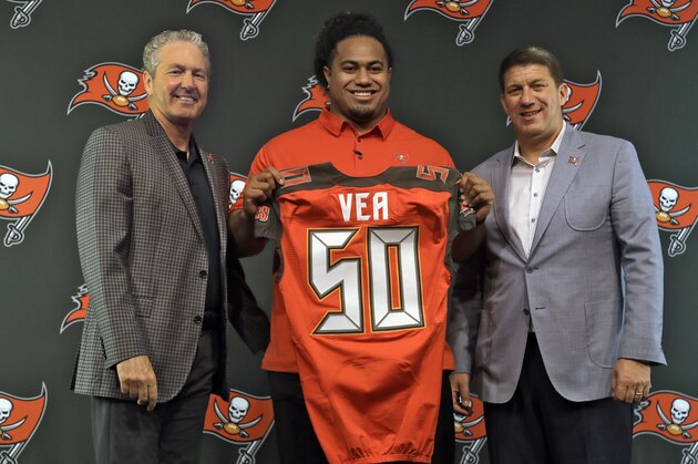 Tampa Bay Buccaneers NFL football first-round draft pick Vita Vea, center, holds up his jersey with head coach Dirk Koetter, left, and general manager Jason Licht, after a news conference Friday, April 27, 2018, in Tampa, Fla. Vea, a defensive lineman, played his college football at Washington. (AP Photo/Chris O'Meara)