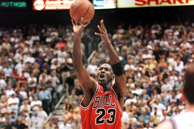 SALT LAKE CITY, UNITED STATES:  In this 14 June 1998 file photo, with 5.2 seconds left in the game, Michael Jordan of the Chicago Bulls (C) aims and shoots the game-winning jump shot as Bryon Russell of the Utah Jazz (L) drives at Jordan's feet 14 June during game six of the NBA Finals with the Utah Jazz at the Delta Center in Salt Lake City, UT. The Bulls won the game 87-86 to win their sixth NBA championship. This would be Jordan's last-ever score if he announces his retirement 13 January as reported in a number of print and broadcast reports. (Photo credit should read JEFF HAYNES/AFP/Getty Images)