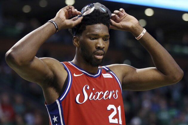 Philadelphia 76ers center Joel Embiid (21) lifts his face mask during a break in the fourth quarter against the Boston Celtics in Game 1 of an NBA basketball second-round playoff series, Monday, April 30, 2018, in Boston. The Celtics won 117-101. (AP Photo/Elise Amendola)