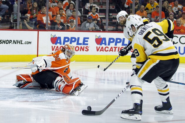 Philadelphia Flyers' Michal Neuvirth, left, goes down to block the shot of Pittsburgh Penguins' Jake Guentzel, (59) who took a pass from Phil Kessel, rear, to score a goal during the third period in Game 6 of an NHL first-round hockey playoff series Sunday, April 22, 2018, in Philadelphia. (AP Photo/Tom Mihalek)