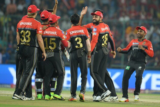Royal Challengers Bangalore team captain Virat Kohli (C with beard)  celebrates with  other team players  the dismissal of Delhi daredevils batsman Sanju Samson (R) during the 2017 Indian Premier League (IPL) Twenty20 cricket match between Delhi Daredevils and Royal Challengers Bangalore   at The Feroz Shah Kotla Cricket Stadium in New Delhi on May 14, 2017. / AFP PHOTO / SAJJAD HUSSAIN        (Photo credit should read SAJJAD HUSSAIN/AFP/Getty Images)