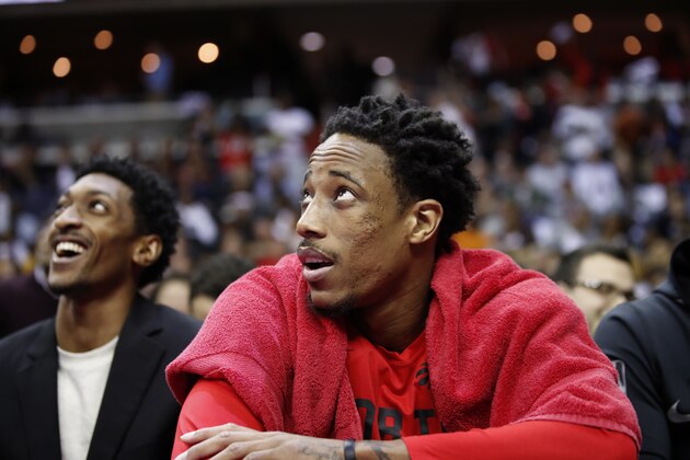 Toronto Raptors guard DeMar DeRozan, right, watches the overhead screen in the first half of Game 6 of an NBA basketball first-round playoff series against the Washington Wizards, Friday, April 27, 2018, in Washington. (AP Photo/Alex Brandon)