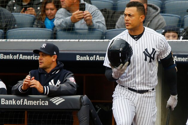 NEW YORK, NY - APRIL 04:  Giancarlo Stanton #27 and manager Aaron Boone #17 of the New York Yankees look on against the Tampa Bay Rays at Yankee Stadium on April 4, 2018 in the Bronx borough of New York City. The Yankees defeated the Rays 7-2.  (Photo by Jim McIsaac/Getty Images)