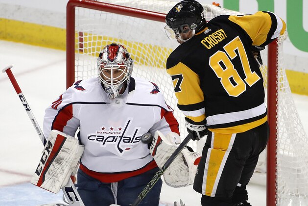 Washington Capitals goaltender Braden Holtby (70) stops a shot and Pittsburgh Penguins' Sidney Crosby (87) can't get his stick on the rebound during the first period in Game 3 of an NHL second-round hockey playoff series in Pittsburgh, Tuesday, May 1, 2018. (AP Photo/Gene J. Puskar)