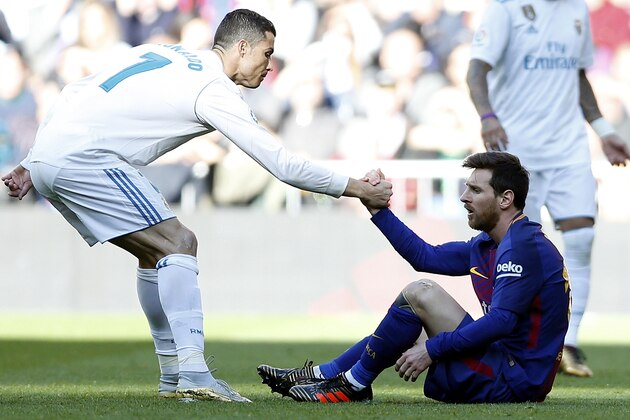 Real Madrid's Cristiano Ronaldo, left, helps Barcelona's Lionel Messi get back on his feet during the Spanish La Liga soccer match between Real Madrid and Barcelona at the Santiago Bernabeu stadium in Madrid, Spain, Saturday, Dec. 23, 2017. (AP Photo/Francisco Seco)