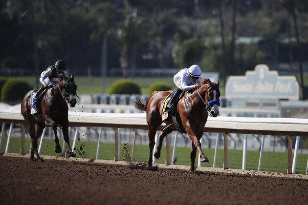 Justify, right, ridden by Mike Smith, heads to the finish line ahead of Bolt d'Oro, with jockey Javier Castellano up, to win the Santa Anita Derby horse race at Santa Anita on Saturday, April 7, 2018, in Arcadia, Calif. (AP Photo/Jae C. Hong)