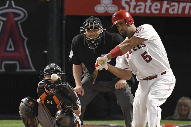 Los Angeles Angels' Albert Pujols, right, hits an RBI double as Chance Sisco, left, watches along with home plate umpire Brian Gorman during the second inning of a baseball game Thursday, May 3, 2018, in Anaheim, Calif. The double marked his 2,999th career hit. (AP Photo/Mark J. Terrill)