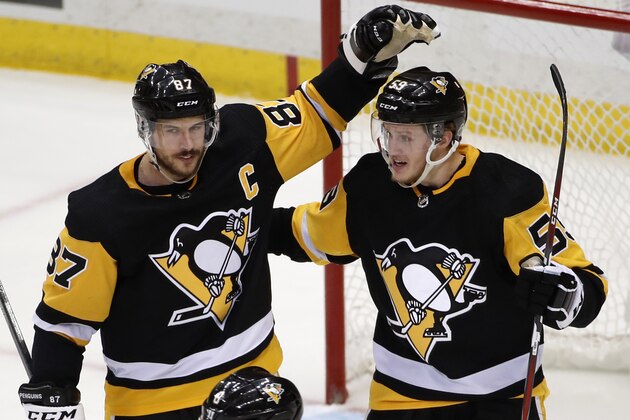 Pittsburgh Penguins' Jake Guentzel (59) celebrates his second goal of the game, an empty-net goal, with Sidney Crosby (87) during the third period in Game 4 of an NHL second-round hockey playoff series against the Washington Capitals in Pittsburgh, Thursday, May 3, 2018. The Penguins won 3-1. (AP Photo/Gene J. Puskar)