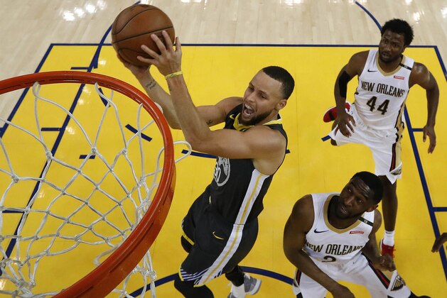 Golden State Warriors' Stephen Curry lays up a shot over New Orleans Pelicans' Ian Clark, right, and Solomon Hill (44) during Game 2 of a second-round NBA basketball playoff series, Tuesday, May 1, 2018, in Oakland, Calif. Golden State won 121-116. (John G. Mabanglo/Pool Photo via AP)
