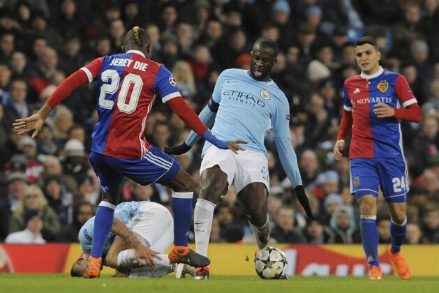 Manchester City's Yaya Toure, center, challenges for the ball with Basel's Geoffroy Serey Die, left, during the Champions League, round of 16, second leg soccer match between Manchester City and Basel at the Etihad Stadium in Manchester, England, Wednesday, March 7, 2018. (AP Photo/Rui Vieira)