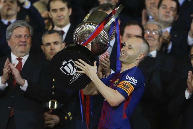 FC Barcelona's Andres Iniesta holds up the trophy as he celebrates during an award ceremony after defeating Sevilla 5-0 in the Copa del Rey final soccer match at the Wanda Metropolitano stadium in Madrid, Spain, Saturday, April 21, 2018. (AP Photo/Francisco Seco)