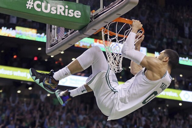 Boston Celtics forward Jayson Tatum (0) hangs on the rim after dunking against the Philadelphia 76ers in the second half of Game 2 of an NBA basketball second-round playoff series, Thursday, May 3, 2018, in Boston. TheCeltics won 108-103. (AP Photo/Elise Amendola)