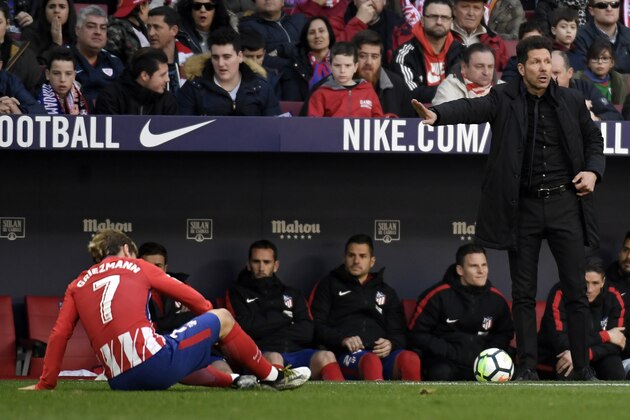 Atletico Madrid's Argentinian coach Diego Simeone (R) gestures as Atletico Madrid's French forward Antoine Griezmann sits on the field during the Spanish league football match between Club Atletico de Madrid vs Athletic Club Bilbao at the Wanda Metropolitano stadium in Madrid on February 18, 2018. / AFP PHOTO / GABRIEL BOUYS        (Photo credit should read GABRIEL BOUYS/AFP/Getty Images)