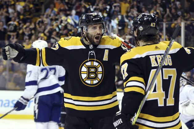 Boston Bruins center Patrice Bergeron (37) celebrates his goal with defenseman Torey Krug (47) during the second period against the Tampa Bay Lightning in Game 4 of an NHL hockey second-round playoff series Friday, May 4, 2018, in Boston. (AP Photo/Elise Amendola)