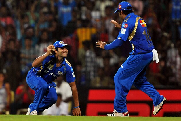 Mumbai Indians' fielder Sarul Kanwar (L) celebrates the catch dismissal of RCB batsman Mohammed Kaif (unseen) with teammate Suryakumar Yadav during the Champions League Twenty20 final match between Royal Challengers Bangalore (RCB) and Mumbai Indians at the M.A Chidambaram Stadium in Chennai on October 9, 2011. RCB is chasing a target of 140 runs set by Mumbain Indians.    AFP PHOTO/ MANJUNATH KIRAN (Photo credit should read Manjunath Kiran/AFP/Getty Images)