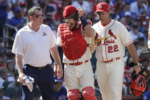 St. Louis Cardinals trainer Chris Conroy, left, and manager Mike Matheny (22) take catcher Yadier Molina back to the dugout after Molina was injured on a pitch during the ninth inning of a baseball game against the Chicago Cubs, Saturday, May 5, 2018, in St. Louis. (AP Photo/Charles Rex Arbogast)