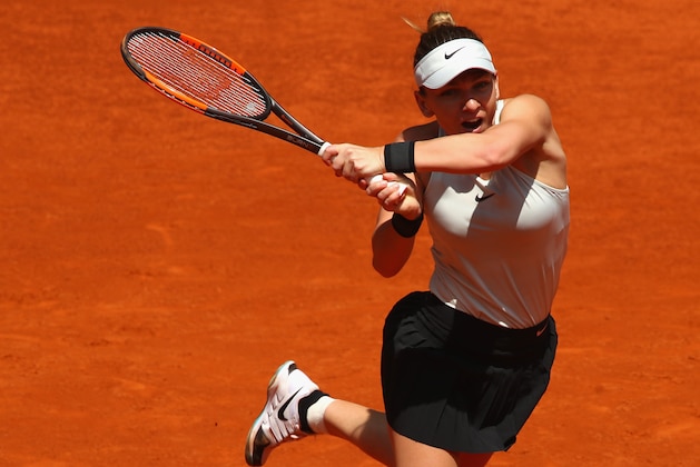 MADRID, SPAIN - MAY 06:  Simona Halep of Romania plays a backhand against Ekaterina Makarova of Russia in their first round match during day two of the Mutua Madrid Open tennis tournament at the Caja Magica on May 6, 2018 in Madrid, Spain.  (Photo by Clive Brunskill/Getty Images)
