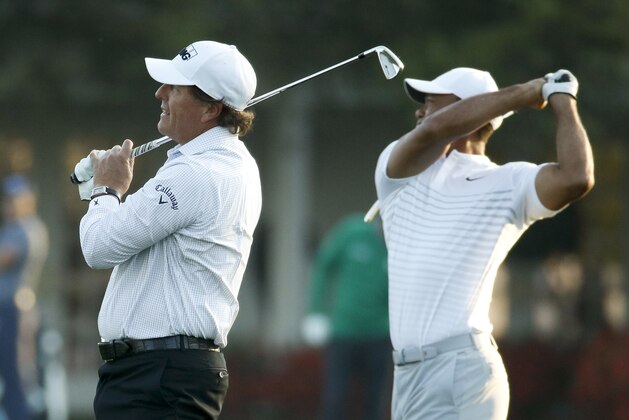 Phil Mickelson, left, and Tiger Woods warm up on the driving range during practice for the Masters golf tournament at Augusta National Golf Club, Tuesday, April 3, 2018, in Augusta, Ga. (AP Photo/Charlie Riedel)