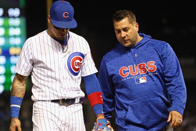 CHICAGO, IL - MAY 07:   Javier Baez #9 of the Chicago Cubs is escorted from the field by trainer Nick Frangella after suffering an apparent injury in the 7th inning against the Miami Marlins at Wrigley Field on May 7, 2018 in Chicago, Illinois. (Photo by Jonathan Daniel/Getty Images)