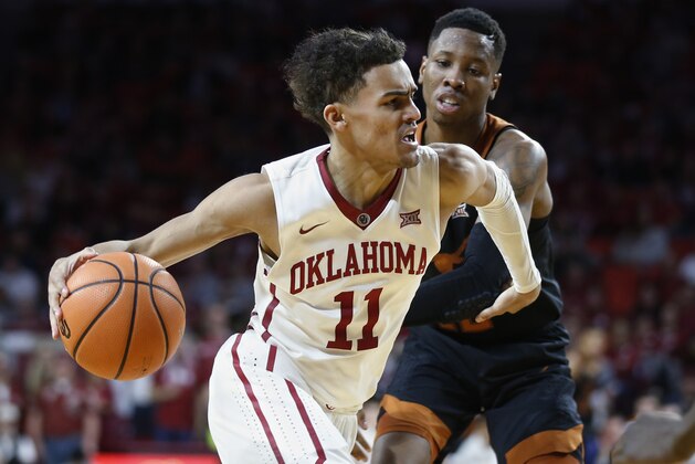 Oklahoma guard Trae Young (11) drives past Texas guard Kerwin Roach II, right, in the second half of an NCAA college basketball game in Norman, Okla., Saturday, Feb. 17, 2018. (AP Photo/Sue Ogrocki)