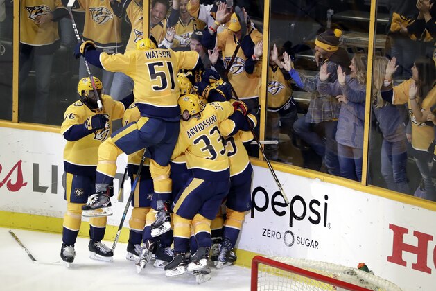 Nashville Predators left wing Austin Watson (51) jumps on the pile as players celebrate after left wing Kevin Fiala score the winning goal against the Winnipeg Jets during the second overtime in Game 2 of an NHL hockey second-round playoff series, Sunday, April 29, 2018, in Nashville, Tenn. The Predators won 5-4 to tie the series 1-1. (AP Photo/Mark Humphrey)