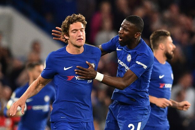 Chelsea's Spanish defender Marcos Alonso (L) celebrates with Chelsea's German defender Antonio Rudiger (R) after Alonso scored their first goal to equalise 1-1 during the English Premier League football match between Chelsea and Huddersfield Town at Stamford Bridge in London on May 9, 2018. (Photo by Glyn KIRK / AFP) / RESTRICTED TO EDITORIAL USE. No use with unauthorized audio, video, data, fixture lists, club/league logos or 'live' services. Online in-match use limited to 75 images, no video emulation. No use in betting, games or single club/league/player publications. /         (Photo credit should read GLYN KIRK/AFP/Getty Images)