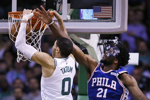 Boston Celtics forward Jayson Tatum (0) dunks after a drive past Philadelphia 76ers center Joel Embiid (21) during the second half of Game 5 of an NBA basketball playoff series in Boston, Wednesday, May 9, 2018. Tatum scored 25 points as the Celtics defeated the 76ers 114-112. (AP Photo/Charles Krupa)