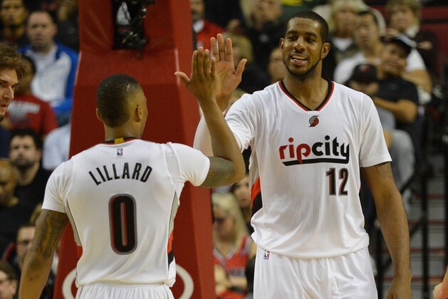 PORTLAND, OR - NOVEMBER 04: Damian Lillard #0 of the Portland Trail Blazers celebrates a basket by LaMarcus Aldridge #12 of the Portland Trail Blazers during the fourth quarter of the game against the Cleveland Cavaliers at Moda Center on November 4, 2014 in Portland, Oregon. NOTE TO USER: User expressly acknowledges and agrees that, by downloading and/or using this photograph, user is consenting to the terms and conditions of the Getty Images License Agreement. Mandatory copyright notice.  (Photo by Steve Dykes/Getty Images)