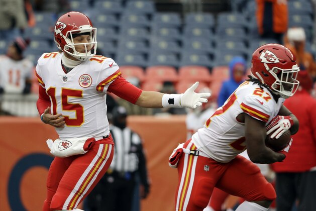 Kansas City Chiefs quarterback Patrick Mahomes, left, hands off to running back Kareem Hunt (27) before an NFL football game against the Denver Broncos Sunday, Dec. 31, 2017, in Denver. (AP Photo/Joe Mahoney )