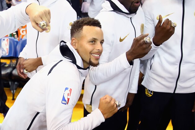 OAKLAND, CA - OCTOBER 17:  Stephen Curry #30 of the Golden State Warriors shows off his championship ring before their game against the Houston Rockets at ORACLE Arena on October 17, 2017 in Oakland, California.  NOTE TO USER: User expressly acknowledges and agrees that, by downloading and or using this photograph, User is consenting to the terms and conditions of the Getty Images License Agreement.  (Photo by Ezra Shaw/Getty Images)