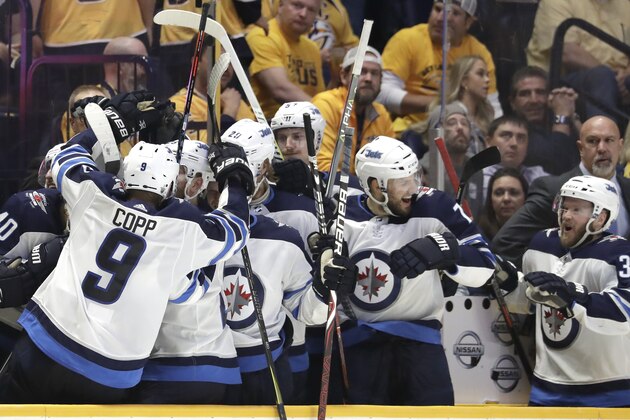 Winnipeg Jets celebrate on the bench after Mark Scheifele, not seen, scored an empty-net goal against the Nashville Predators to seal the Jets' 5-1 win, late in the third period in Game 7 of an NHL hockey second-round playoff series Thursday, May 10, 2018, in Nashville, Tenn. The Jets won the series. (AP Photo/Mark Humphrey)
