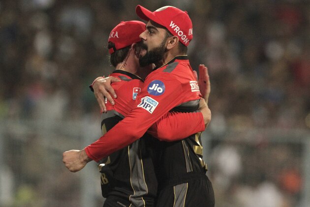 Royal Challengers Bangalore's Virat Kohli, right and AB de Villiers celebrate dismissal of Kolkata Knight Riders' Chris Lynn during VIVO IPL cricket T20 match in Kolkata, India, Sunday, April 8, 2018. (AP Photo/Bikas Das)