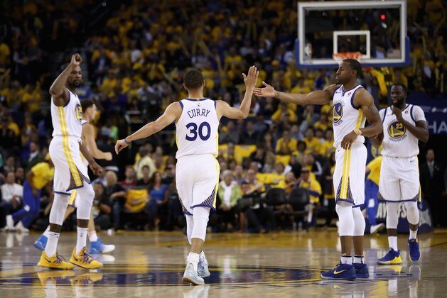 OAKLAND, CA - MAY 08:  Stephen Curry #30 of the Golden State Warriors is congratulated by Andre Iguodala #9 and Kevin Durant #35 after he made a basket against the New Orleans Pelicans during Game Five of the Western Conference Semifinals of the 2018 NBA Playoffs at ORACLE Arena on May 8, 2018 in Oakland, California.  NOTE TO USER: User expressly acknowledges and agrees that, by downloading and or using this photograph, User is consenting to the terms and conditions of the Getty Images License Agreement.  (Photo by Ezra Shaw/Getty Images)