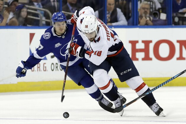 Washington Capitals center Chandler Stephenson (18) breaks out past Tampa Bay Lightning center Yanni Gourde (37) during the third period of Game 1 of the NHL Eastern Conference finals hockey playoff series Friday, May 11, 2018, in Tampa, Fla. (AP Photo/Chris O'Meara)