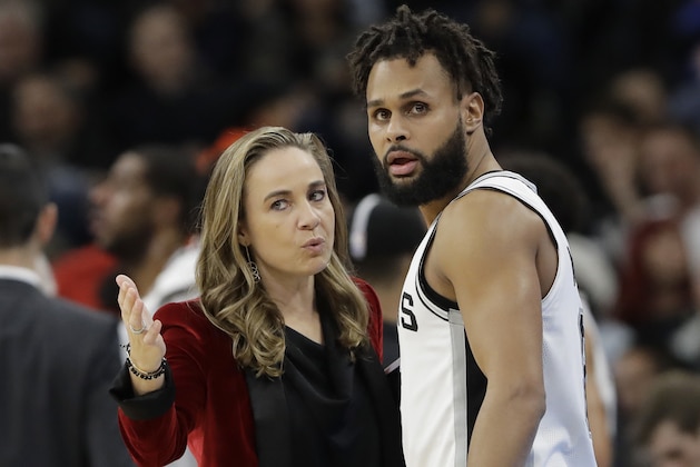 San Antonio Spurs assistant coach Becky Hammon, left, talks with guard Patty Mills (8) during the second half of an NBA basketball game against the New York Nets, Tuesday, Dec. 26, 2017, in San Antonio. San Antonio won 109-97.(AP Photo/Eric Gay)