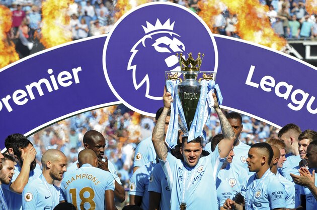 Manchester City's goalkeeper Ederson Moraes lifts the English Premier League trophy after the soccer match between Manchester City and Huddersfield Town at Etihad stadium in Manchester, England, Sunday, May 6, 2018. (AP Photo/Rui Vieira)
