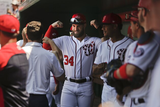 Washington Nationals' Bryce Harper flexes his arms as he waits in the dugout with his teammates for the start of a baseball game against the Pittsburgh Pirates at Nationals Park, Thursday, May 3, 2018, in Washington. (AP Photo/Pablo Martinez Monsivais)