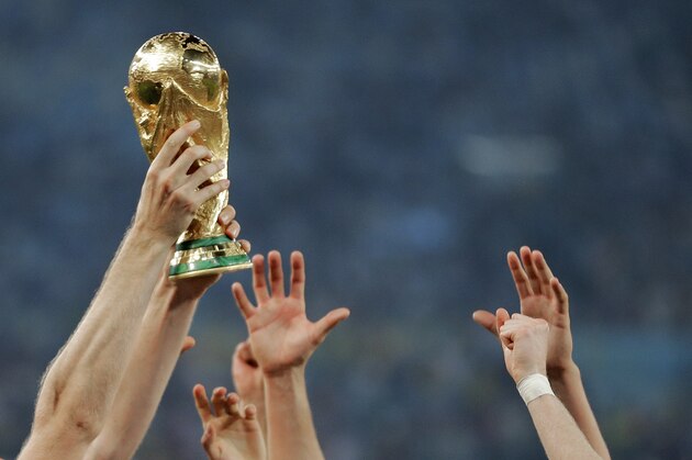 FILE - In this Sunday, July 13, 2014 file photo, German players reach out to touch the trophy after the World Cup final soccer match between Germany and Argentina at the Maracana Stadium in Rio de Janeiro, Brazil. Morocco will bid to host the 2026 World Cup, giving a joint bid from North America some competition. The Morocco Football Federation announced its intention to bid on Friday, Aug. 11, 2017 the deadline for countries to express their interest. (AP Photo/Matthias Schrader, File)