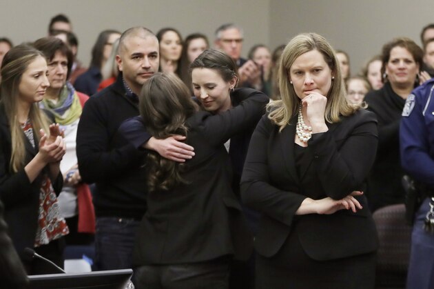 Former gymnast Rachael Denhollander, center, is hugged after giving her victim impact statement during the seventh day of Larry Nassar's sentencing hearing Wednesday, Jan. 24, 2018, in Lansing, Mich. At right is Assistant Attorney General Angela Povilaitis. Nassar has admitted sexually assaulting athletes when he was employed by Michigan State University and USA Gymnastics, which is the sport's national governing organization and trains Olympians. (AP Photo/Carlos Osorio)