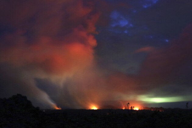 Lava shoots into the night sky from active fissures on the lower east rift of the Kilauea volcano, Tuesday, May 15, 2018, near Pahoa, Hawaii. (AP Photo/Caleb Jones)