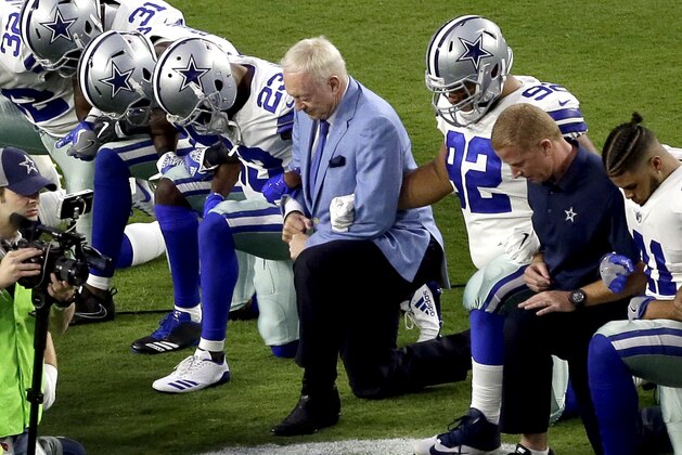 FILE - In this Monday, Sept. 25, 2017, file photo, the Dallas Cowboys, led by owner Jerry Jones, center, take a knee prior to the national anthem and an NFL football game against the Arizona Cardinals, in Glendale, Ariz. ESPN anchor Jemele Hill has been suspended by the network for two weeks for making political statements on social media.  Hill, who is African-American, received criticism from the network last month after referring to President Donald Trump as a