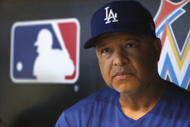 Los Angeles Dodgers manager Dave Roberts looks out of the dugout as he speaks to members of the media before the start of a baseball game against the Miami Marlins, Wednesday, May 16, 2018, in Miami. (AP Photo/Wilfredo Lee)