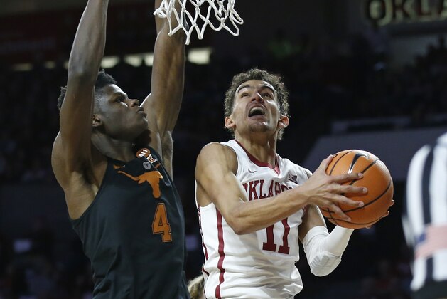 Oklahoma guard Trae Young (11) goes to the basket in front of Texas forward Mohamed Bamba (4) in the second half of an NCAA college basketball game in Norman, Okla., Saturday, Feb. 17, 2018. (AP Photo/Sue Ogrocki)