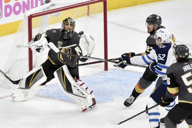 Vegas Golden Knights goaltender Marc-Andre Fleury, left, blocks a shot by Winnipeg Jets center Jack Roslovic during the second period of Game 3 of the NHL hockey playoffs Western Conference finals Wednesday, May 16, 2018, in Las Vegas. (AP Photo/David Becker)